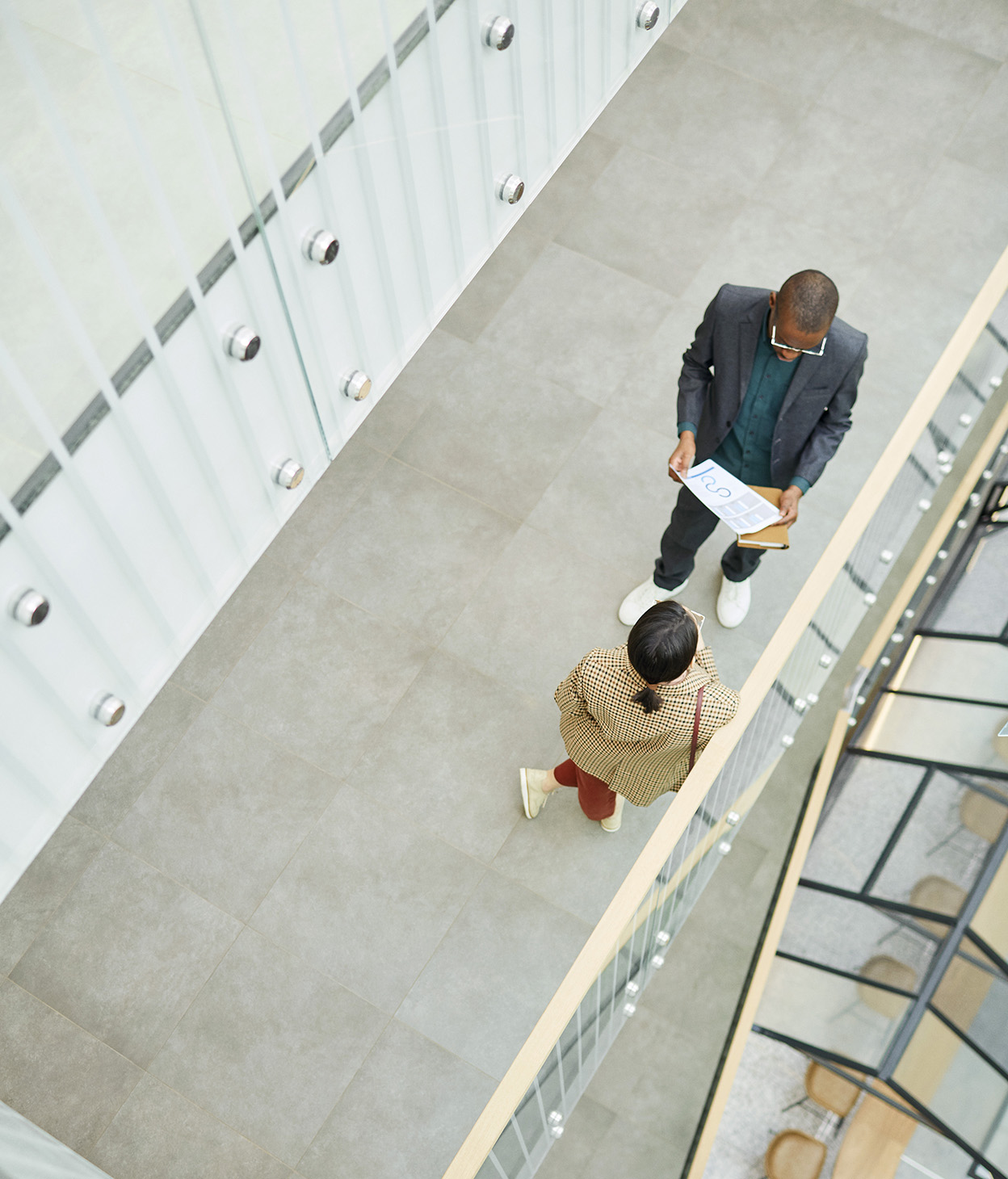 Male and female coworkers speaking in hallway